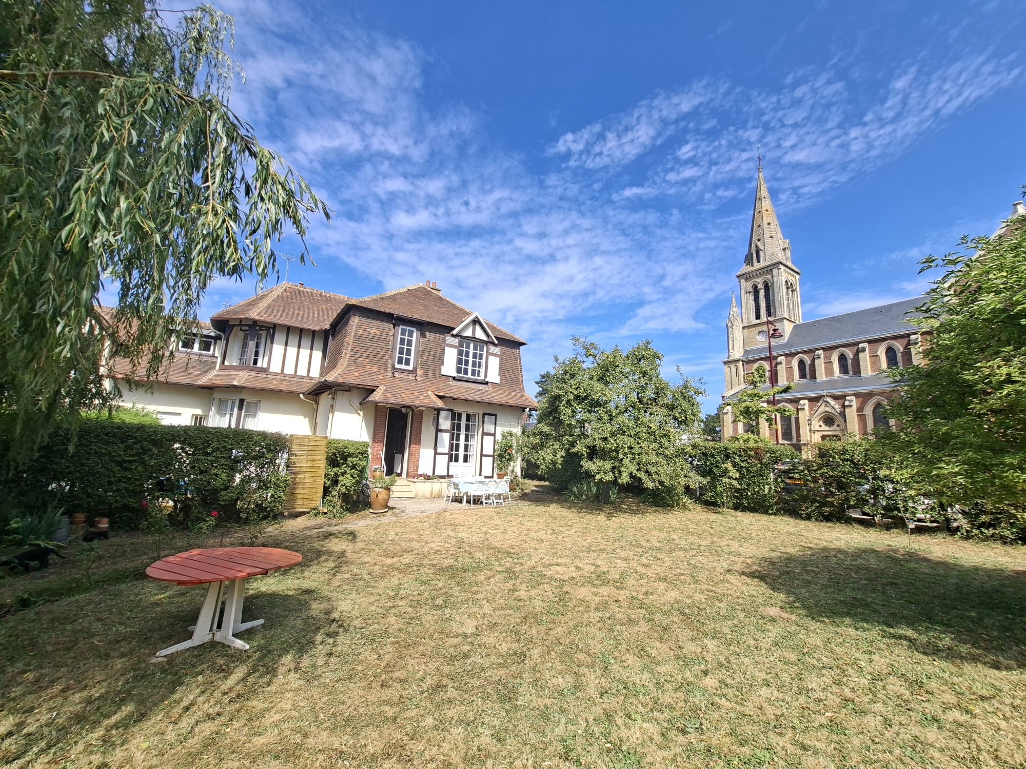 Maison Anne-Marie vue du jardin, avec l'église de Houlgate en arrière-plan